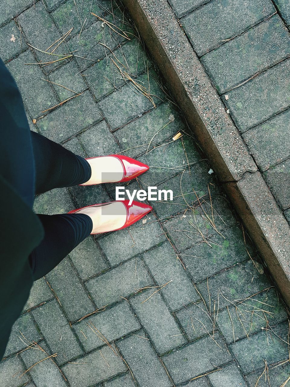 Low section of woman standing on footpath