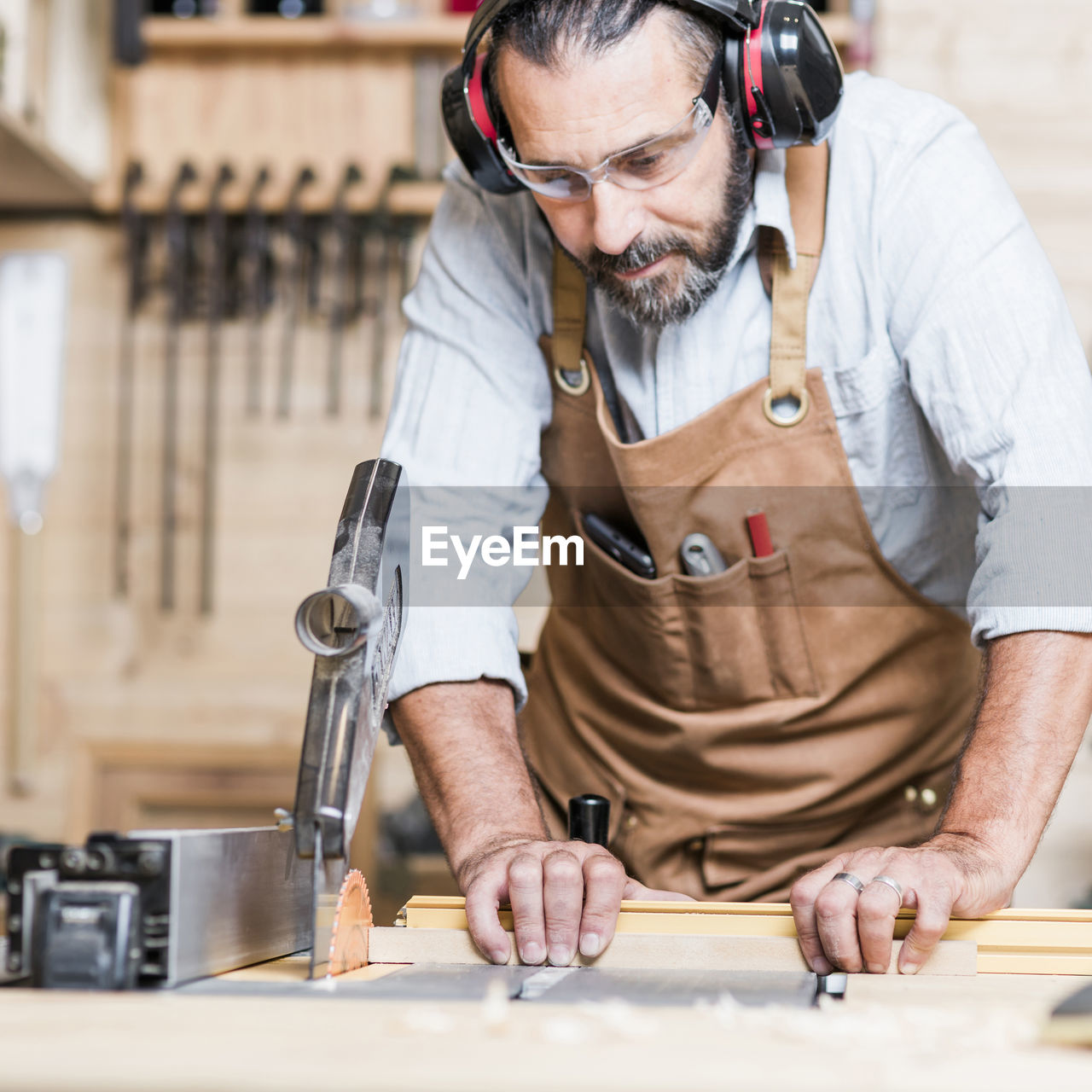 Carpenter listening music while working in workshop