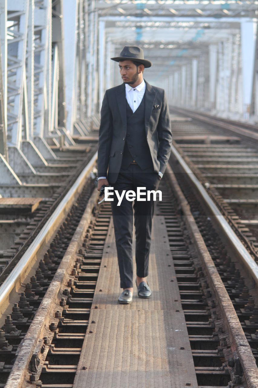 Full length of man standing at railroad tracks