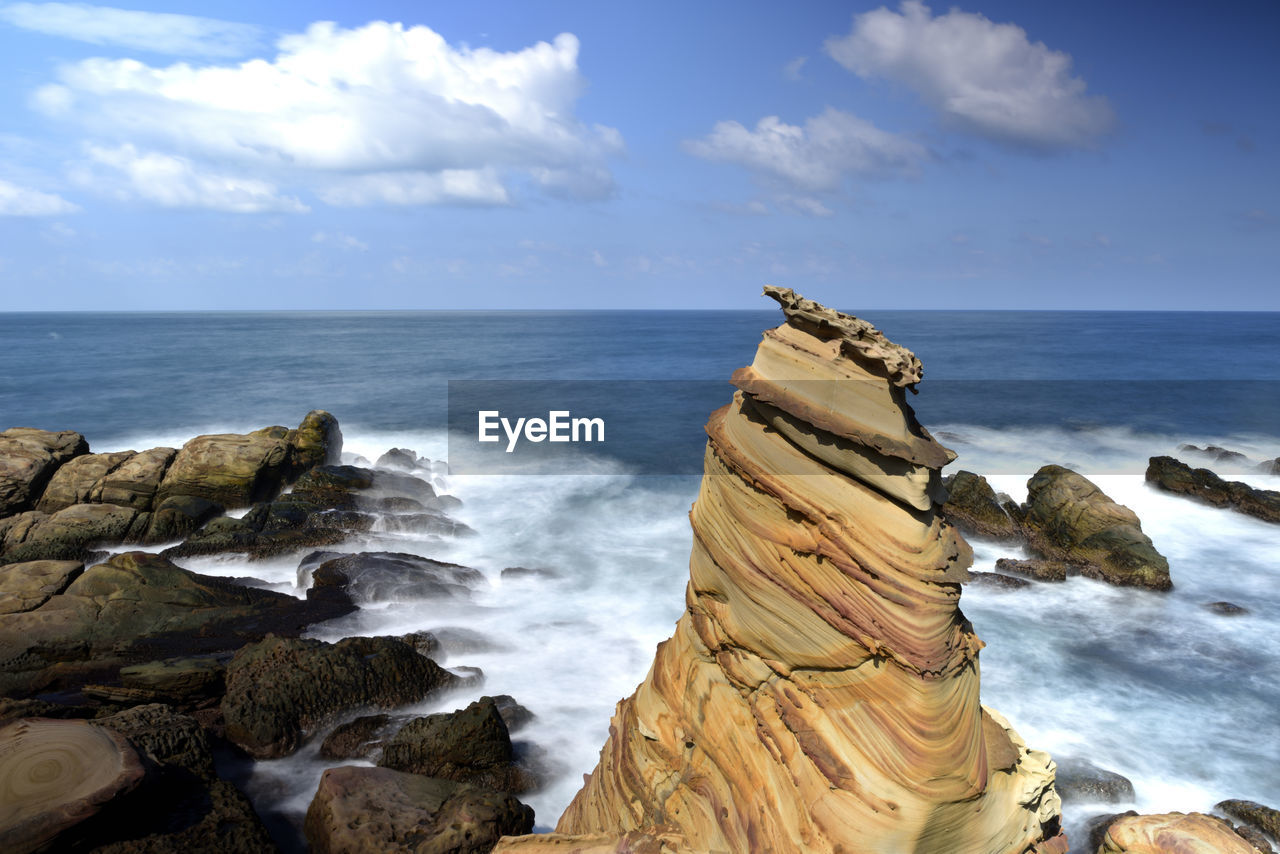 SCENIC VIEW OF ROCKS ON SHORE AGAINST SKY