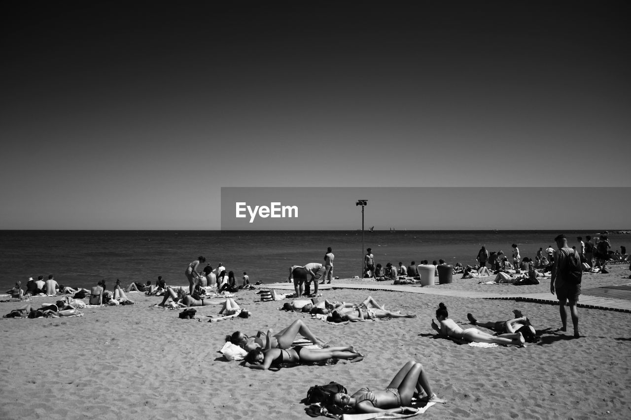 VIEW OF PEOPLE ON BEACH AGAINST CLEAR SKY