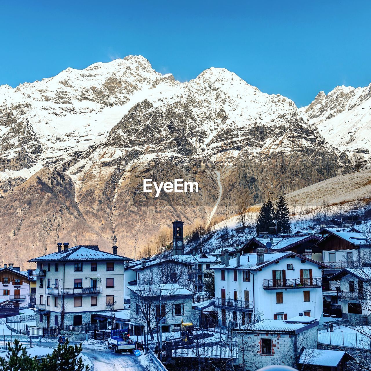 Houses on snowcapped mountain against sky