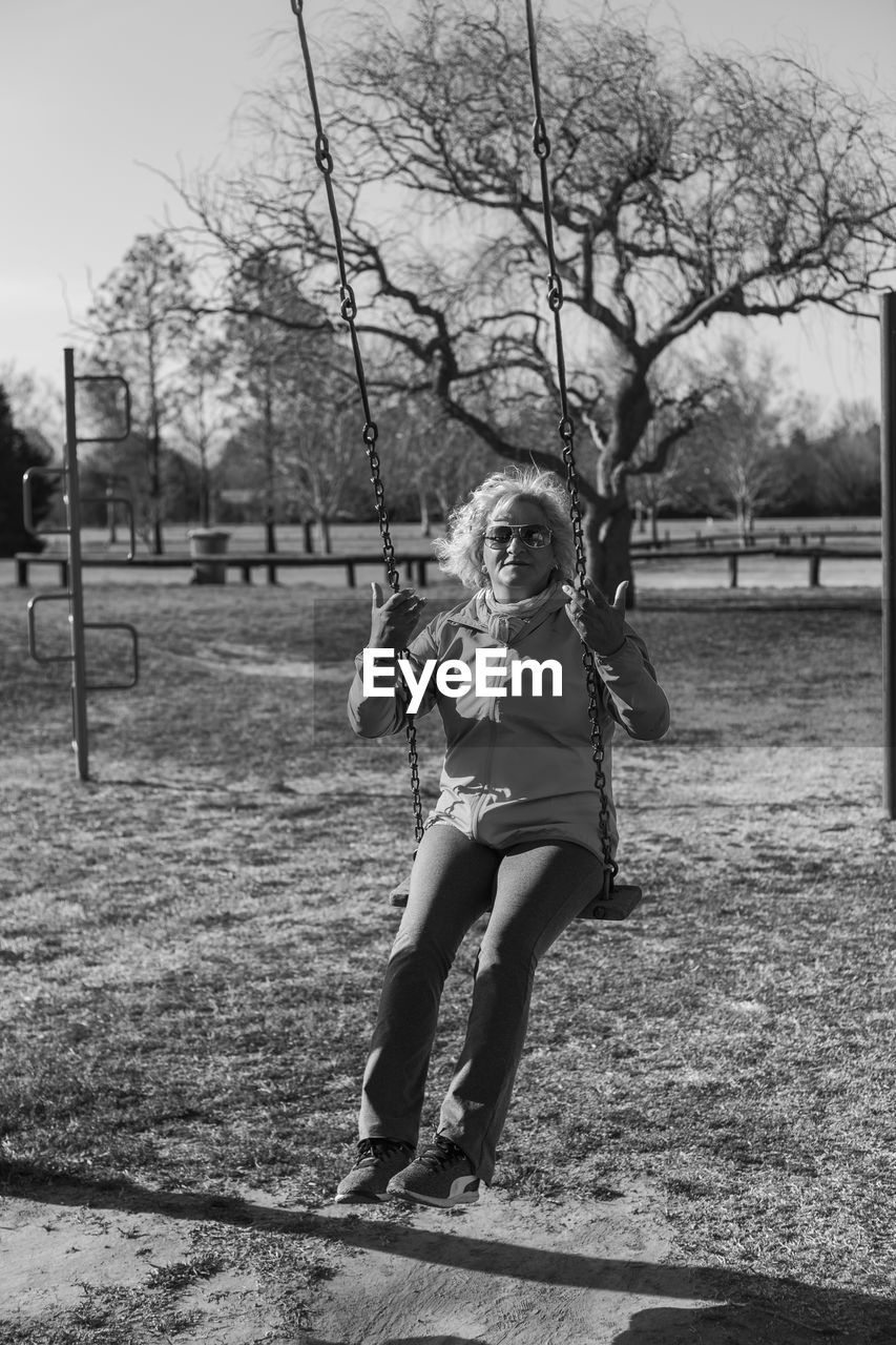 PORTRAIT OF HAPPY GIRL ON FIELD AGAINST TREES