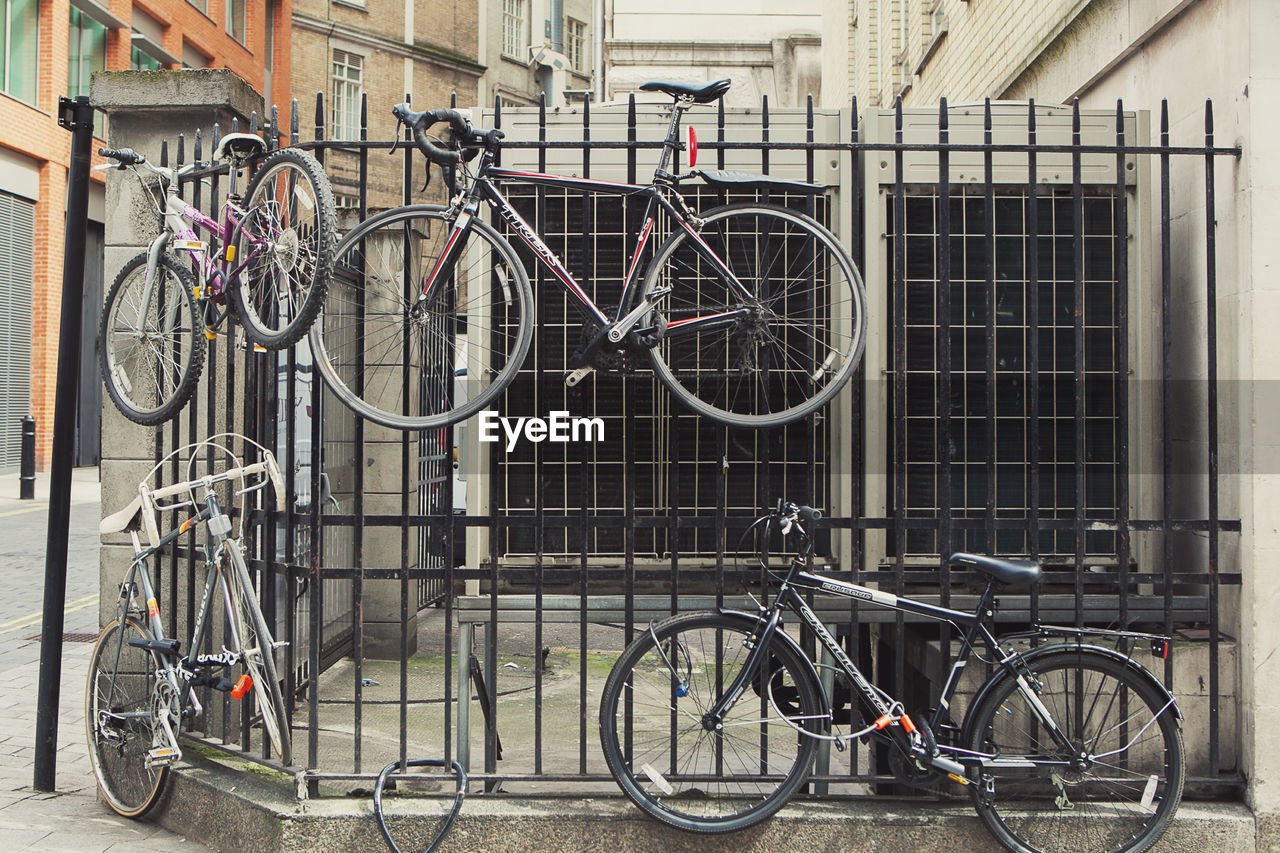 BICYCLES ON BICYCLE AGAINST BUILDING IN CITY