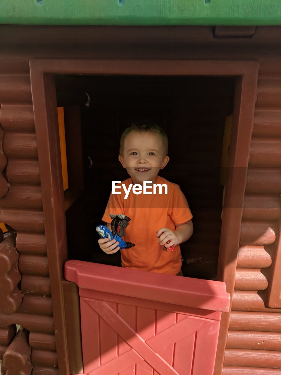 Portrait of smiling boy holding toy in hut