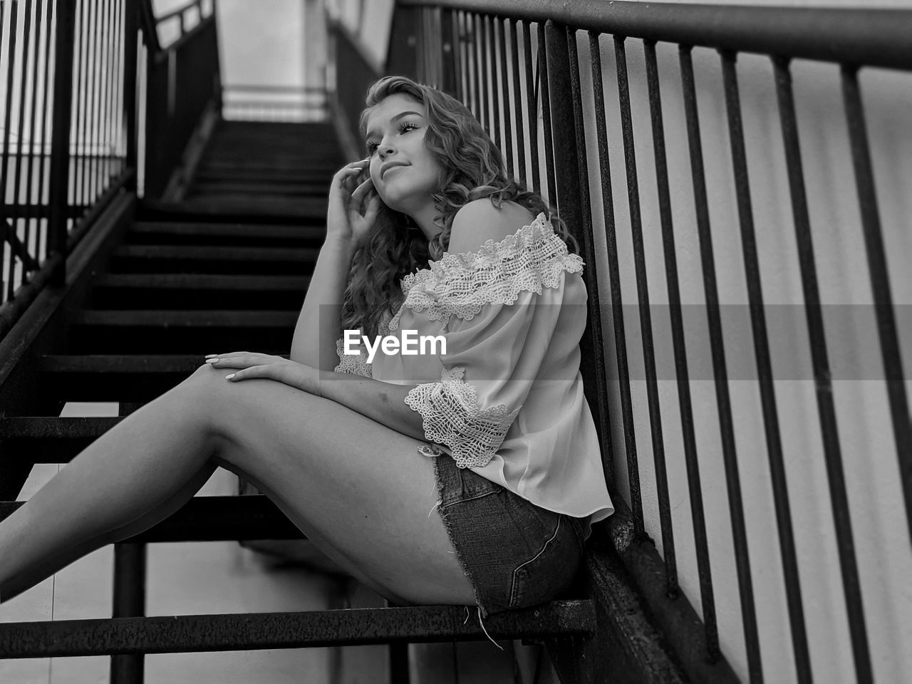 Full length of woman sitting on staircase