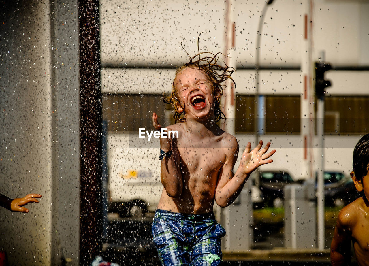 Shirtless boy playing with water