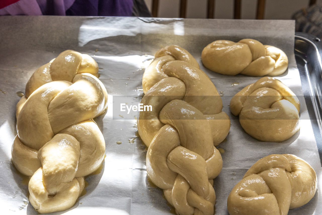 Baking homemade challah bread. a braid with sesame seeds in a pan before baking