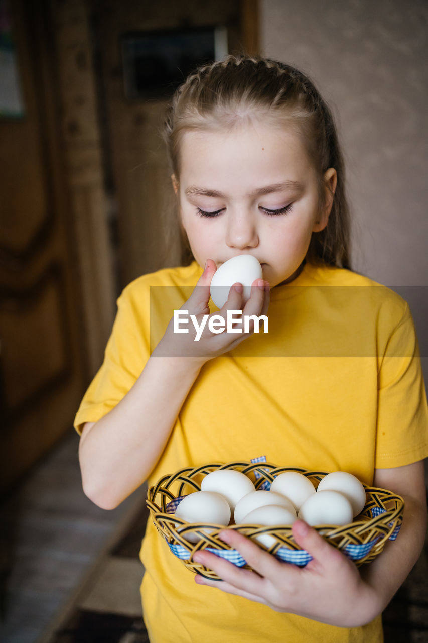 Girl with a basket of white easter eggs