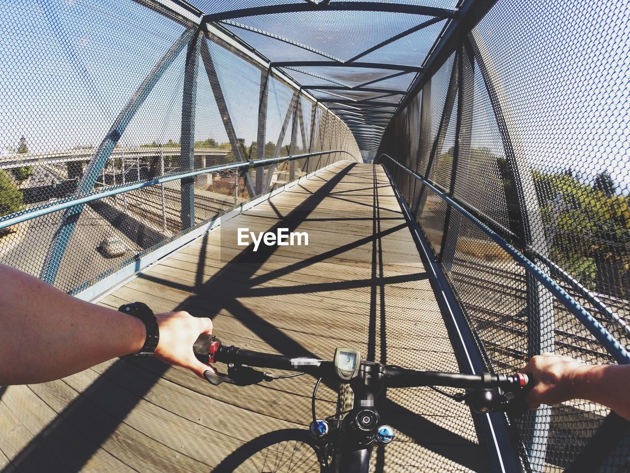 Cropped image of man riding bicycle on bridge