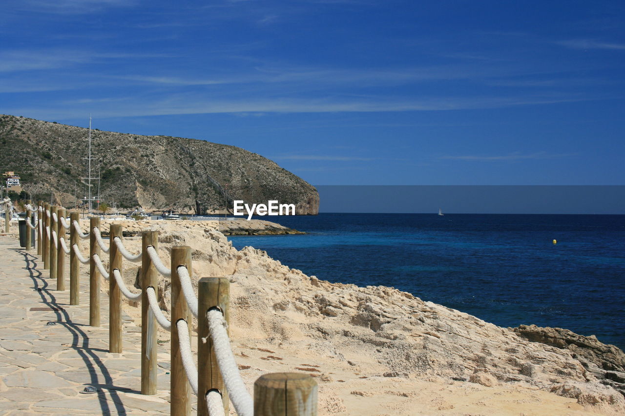 SCENIC VIEW OF BEACH AGAINST BLUE SKY