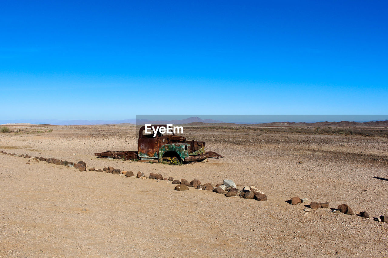 TRACTOR ON LAND AGAINST CLEAR SKY