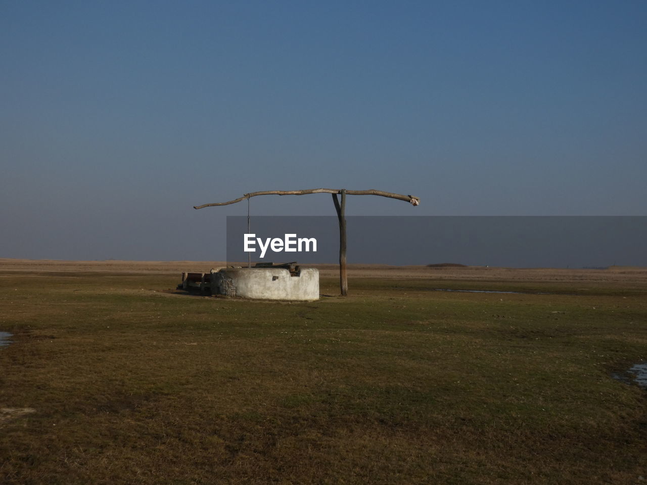 WINDMILLS ON FIELD AGAINST SKY