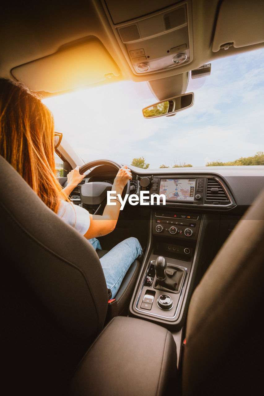 rear view of woman using mobile phone while sitting in car