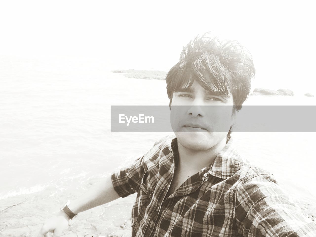 Portrait of young man standing at beach