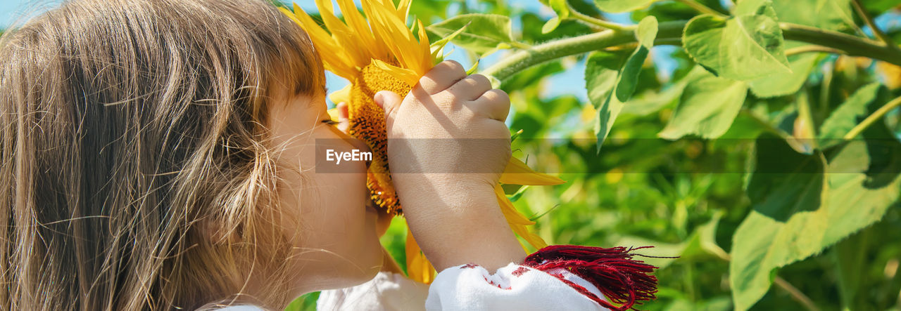 Cute girl smelling sunflower