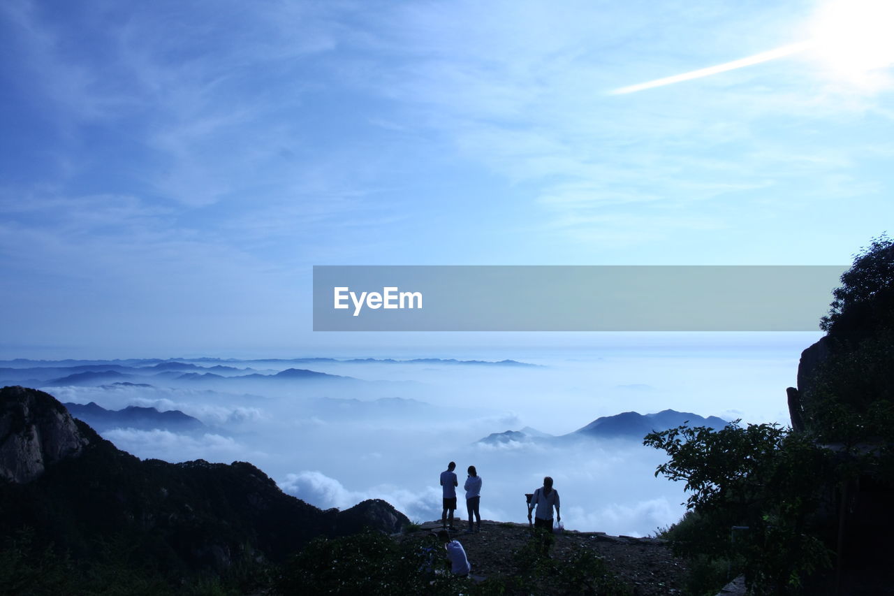 People standing on mountain against sky