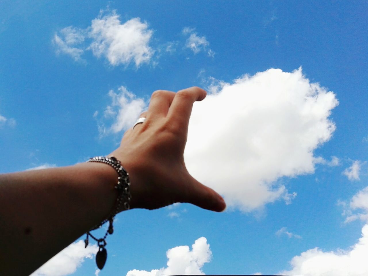 LOW ANGLE VIEW OF HANDS AGAINST BLUE SKY