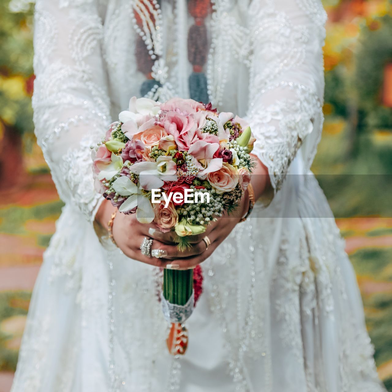 Midsection of a bride holding flower bouquet
