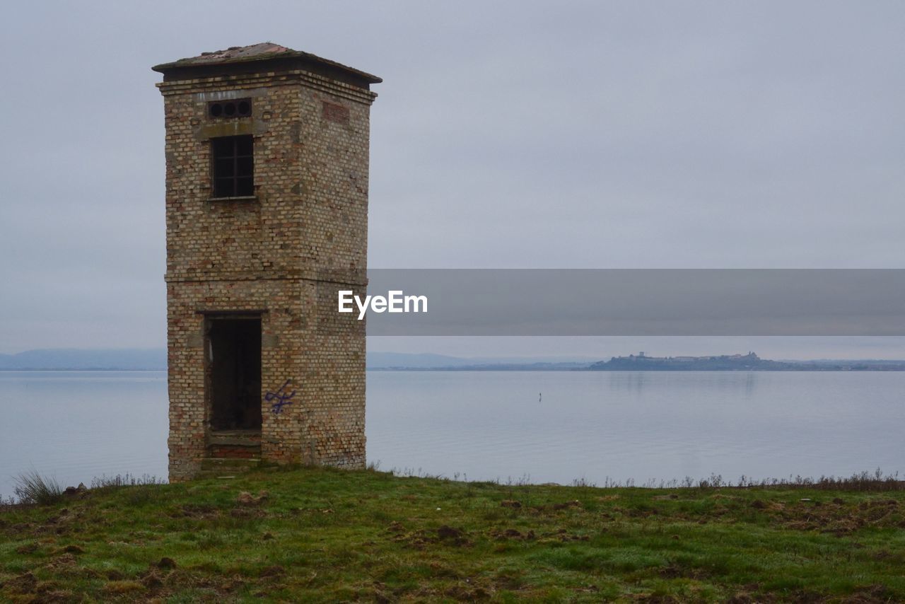 tower, water, architecture, built structure, sky, building exterior, nature, sea, coast, history, building, no people, land, the past, beach, travel destinations, grass, lighthouse, scenics - nature, travel, outdoors, cloud, environment, plant, day, tourism, landscape, tranquility, beauty in nature, old, coastline, tranquil scene, non-urban scene