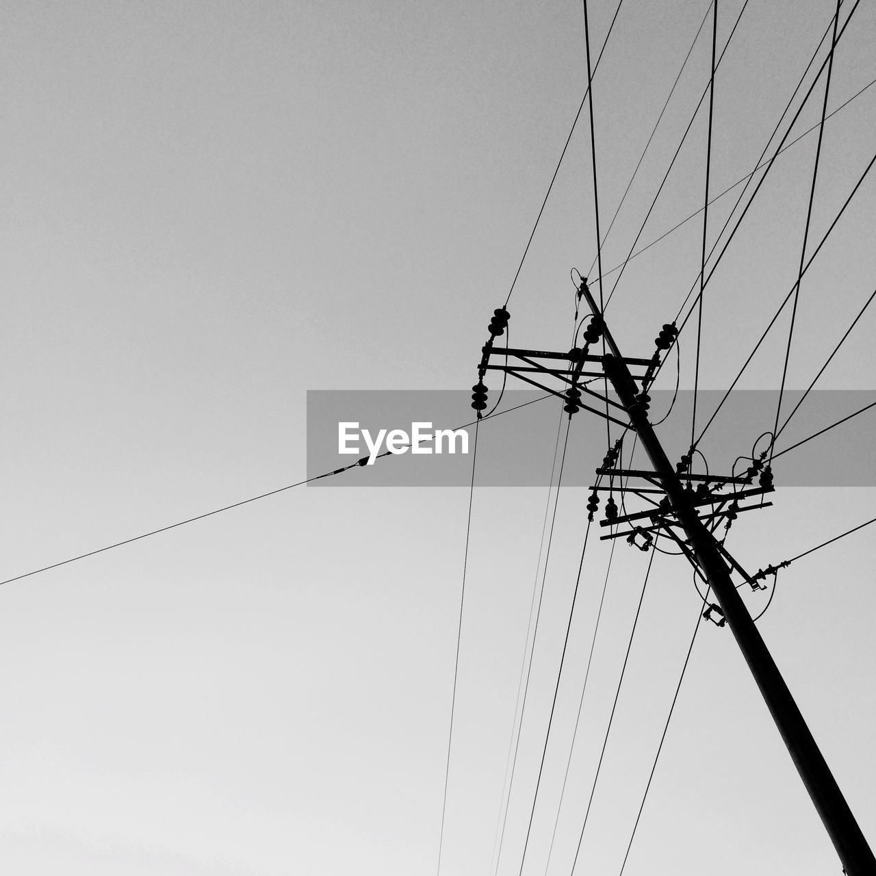 Silhouette electricity pylon against clear sky