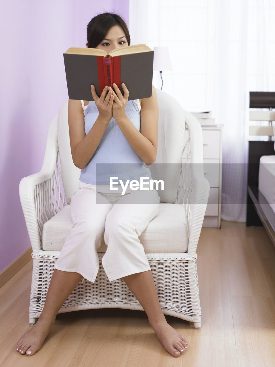 WOMAN SITTING ON BOOK