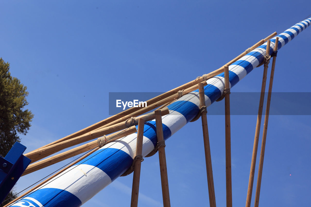 LOW ANGLE VIEW OF CABLES AGAINST BLUE SKY AND CLEAR BACKGROUND