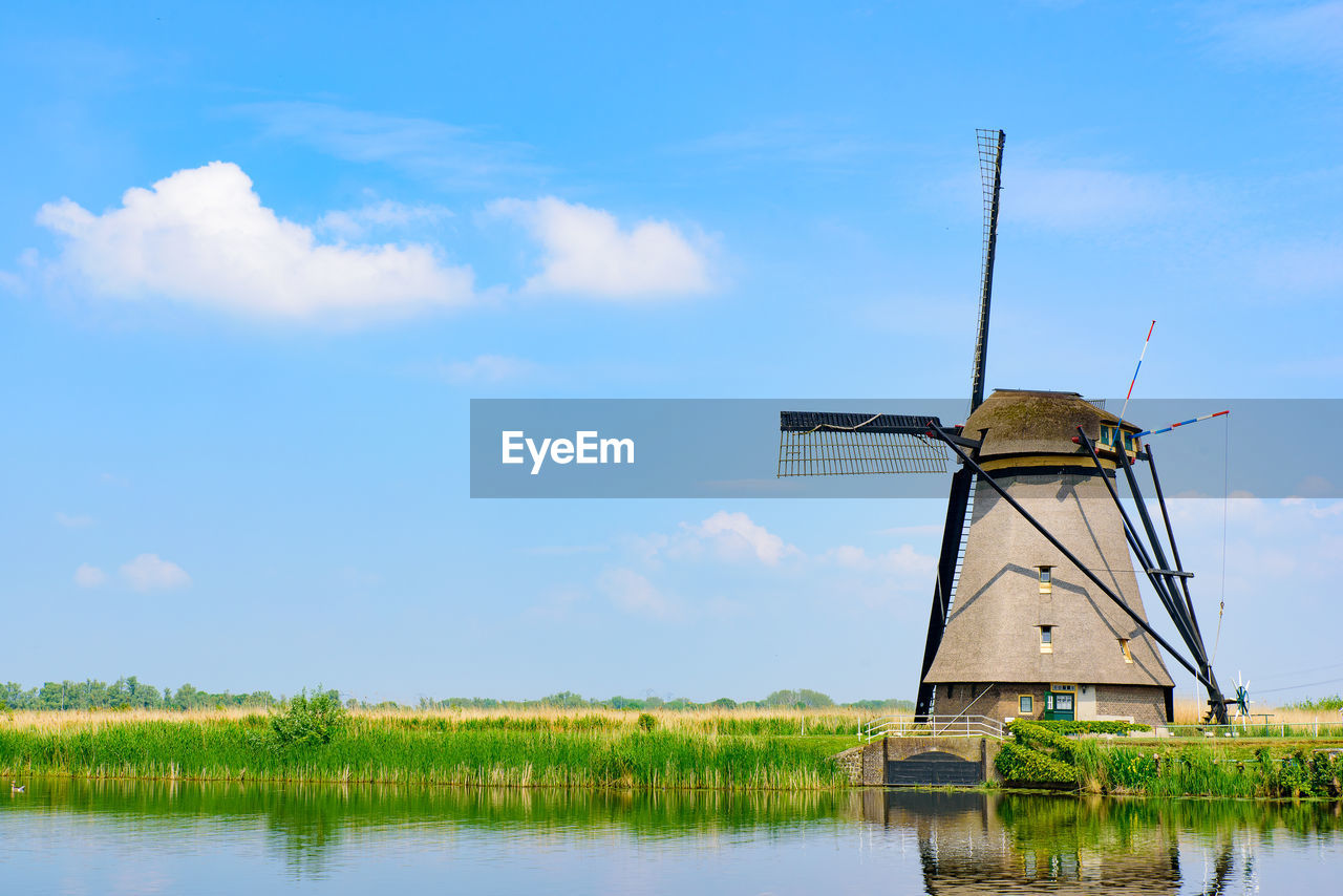 TRADITIONAL WINDMILL ON LANDSCAPE AGAINST SKY