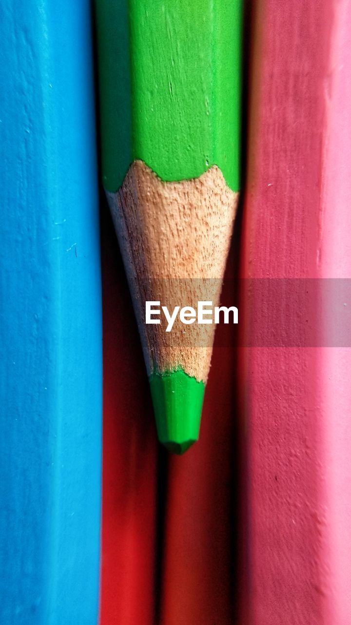 CLOSE-UP OF MULTI COLORED PENCILS ON WOOD