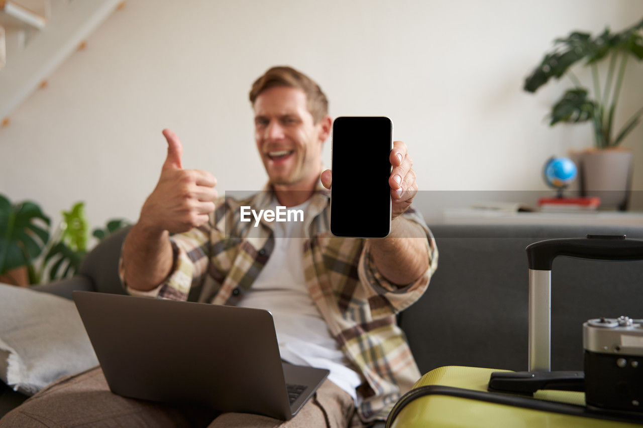 midsection of woman using mobile phone while sitting on table