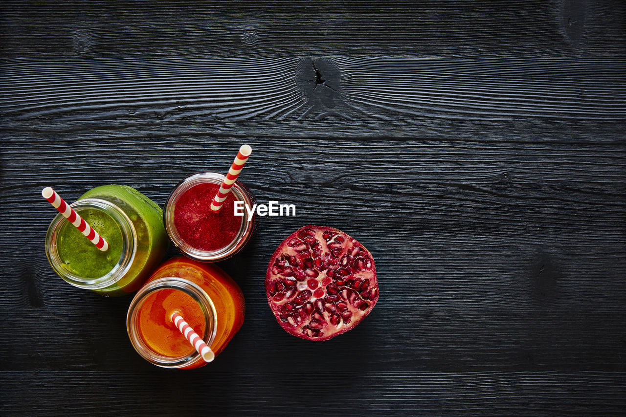 Close-up of smoothie in jars with pomegranate on table