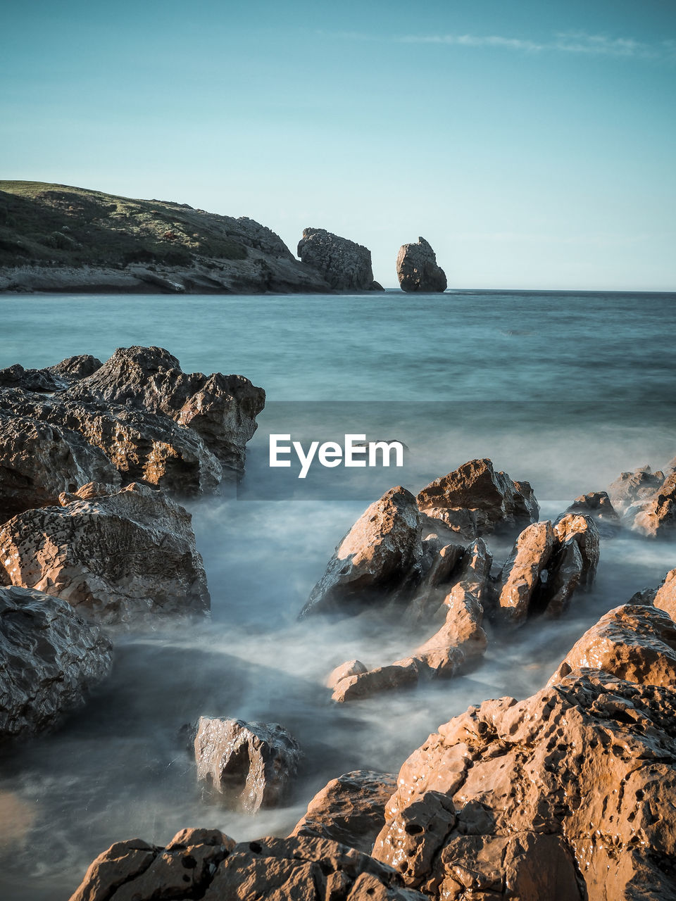 Scenic view of rocks in sea against sky