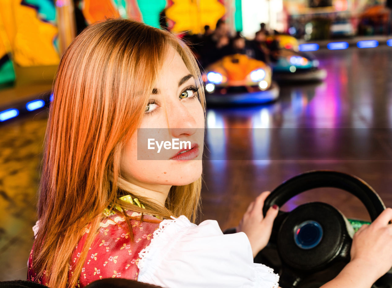 Portrait of woman sitting in bumper car at amusement park