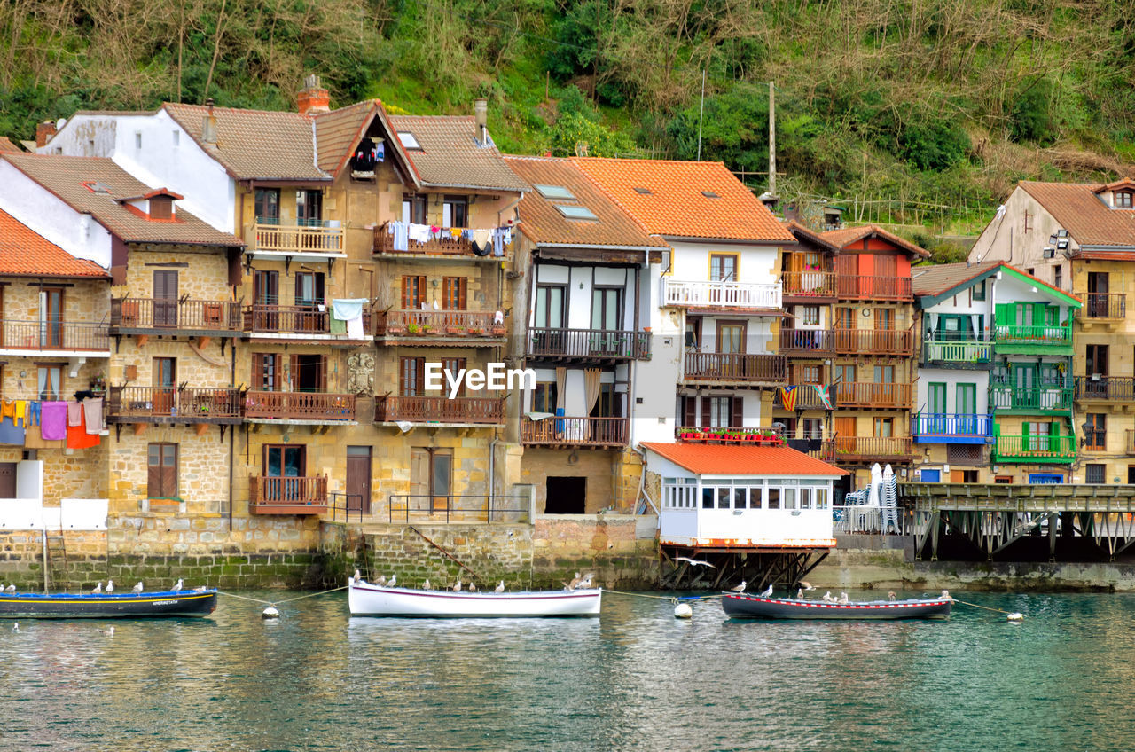 HOUSES BY RIVER AGAINST BUILDINGS