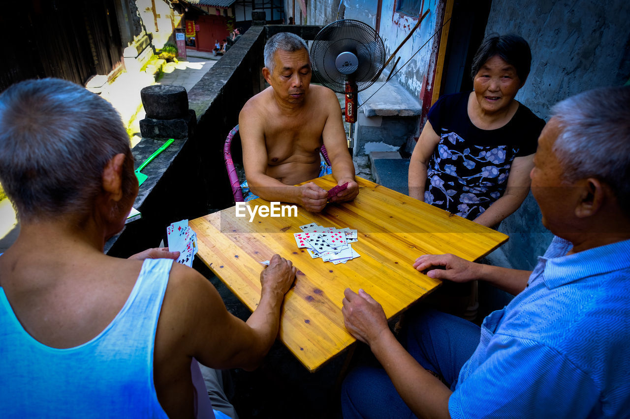 GROUP OF FRIENDS SITTING ON TABLE AT HOME