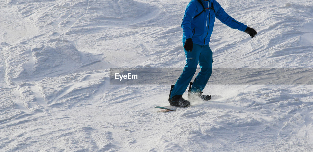 winter, snow, cold temperature, leisure activity, sports, one person, mountain, winter sports, vacation, full length, holiday, nature, trip, day, ski mountaineering, piste, lifestyles, skiing, mountain range, adventure, environment, clothing, ski touring, footwear, extreme sports, sports equipment, white, ski holiday, adult, land, warm clothing, activity, beauty in nature, travel, sunlight, landscape, men, recreation, outdoors, snowboarding, motion, travel destinations, ski-wear, rear view, nordic skiing, ski equipment, vitality, downhill, non-urban scene, scenics - nature, ski, shadow, frozen