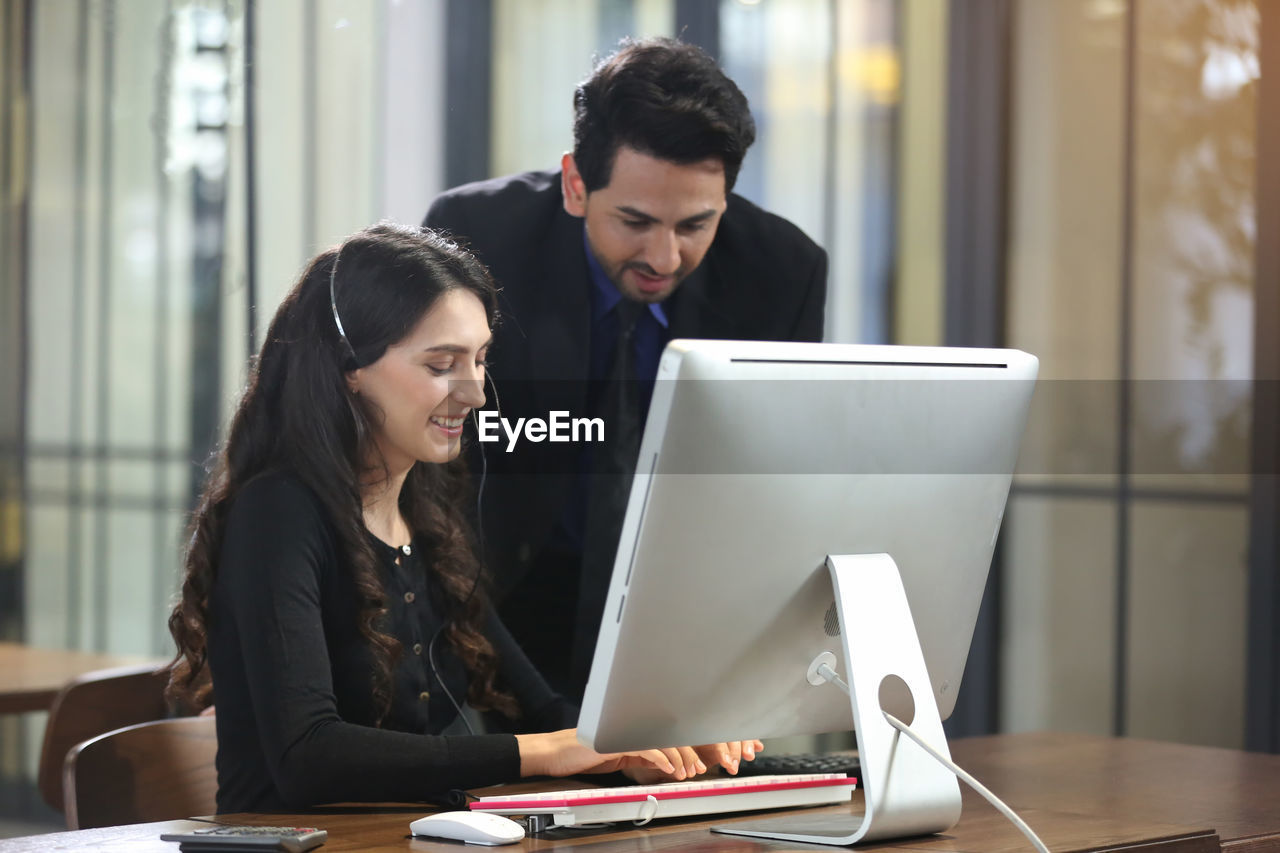 Young couple looking at camera while sitting on table