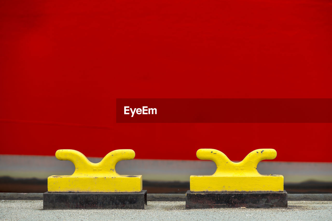 Close-up of yellow mooring hooks on jetty