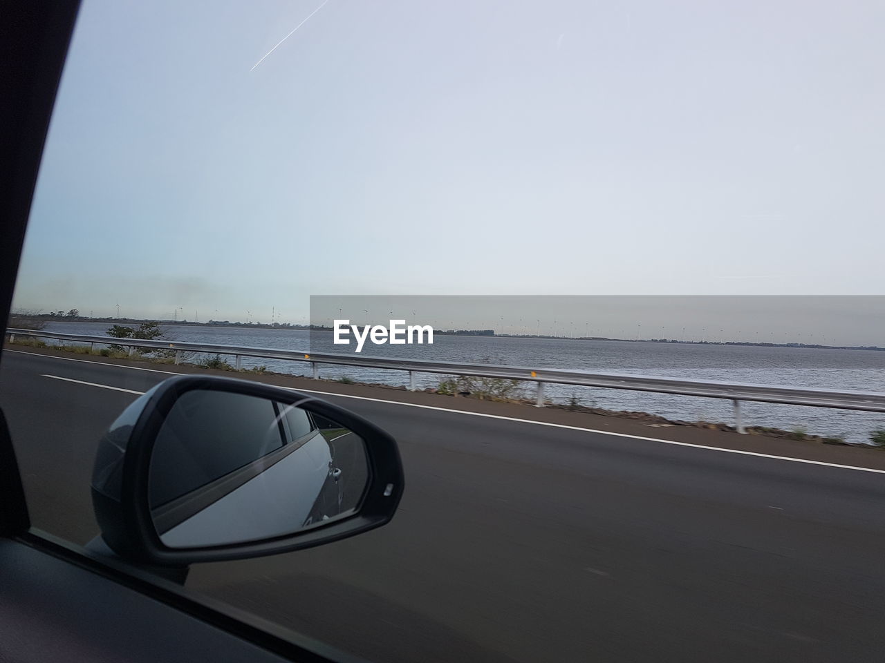 Close-up of side-view mirror against clear sky