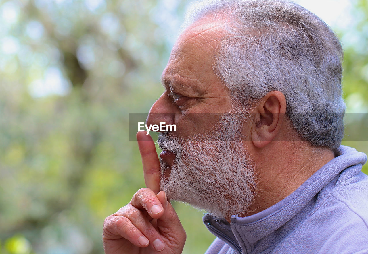 Close-up of senior man with finger on lips