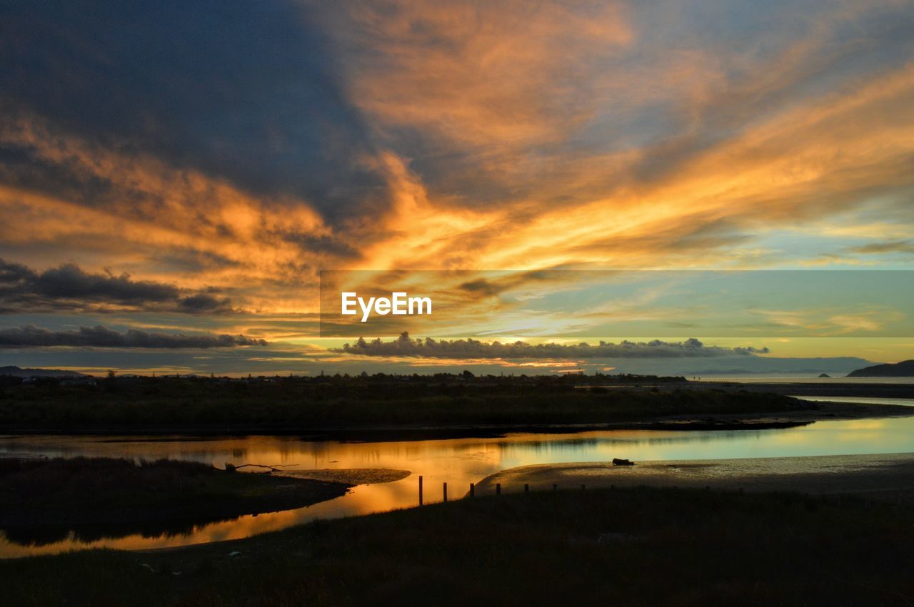 SCENIC VIEW OF DRAMATIC SKY OVER LAKE DURING SUNSET