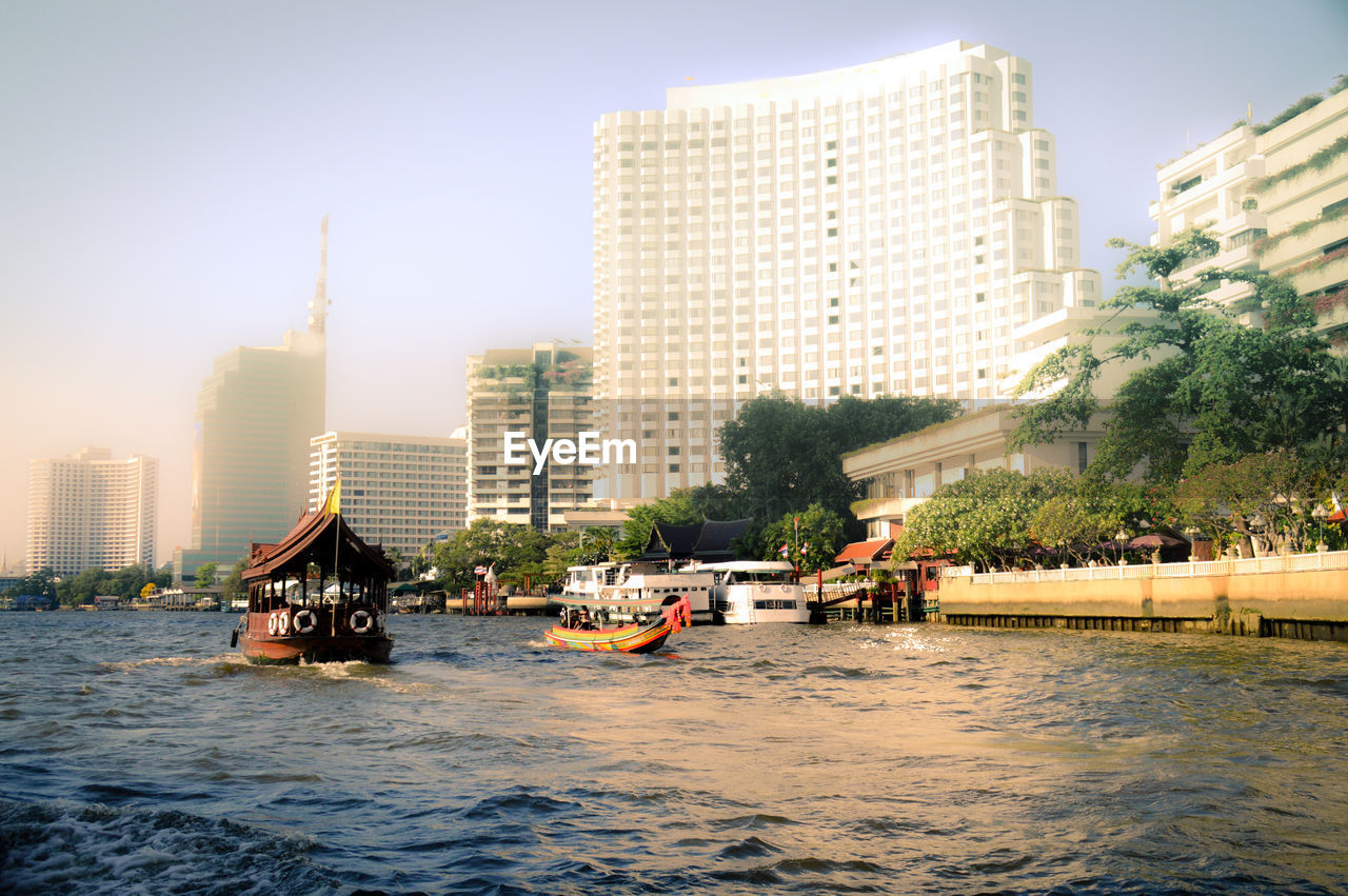 City by river against clear sky