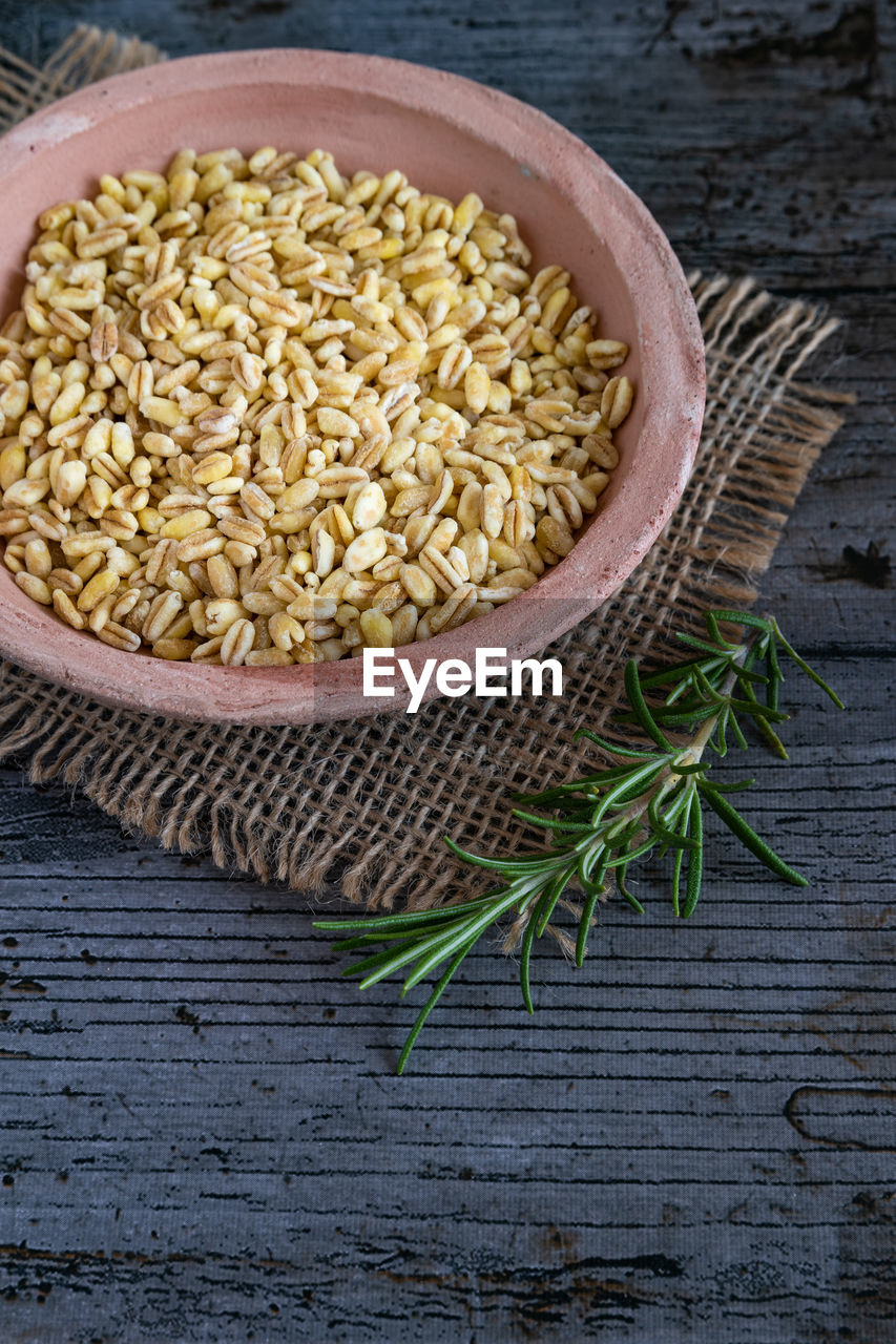 Uncooked wheat grains grown in france on rustic background