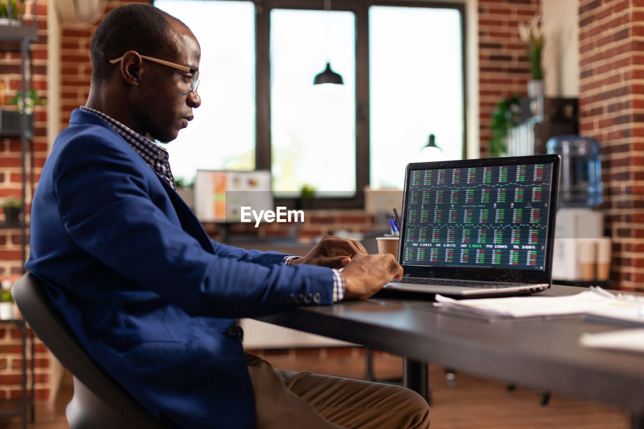 midsection of man using laptop on table