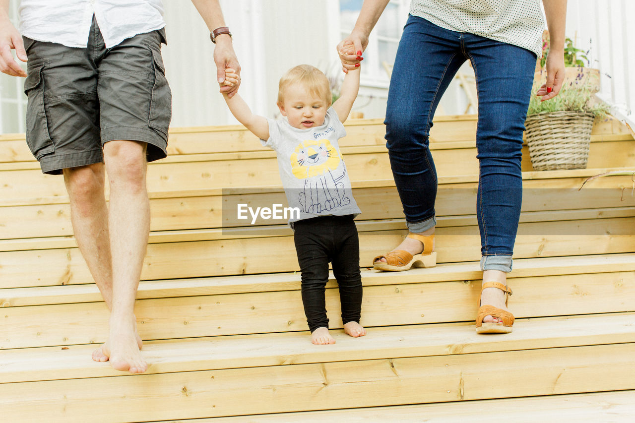 Baby boy with parents walking on steps