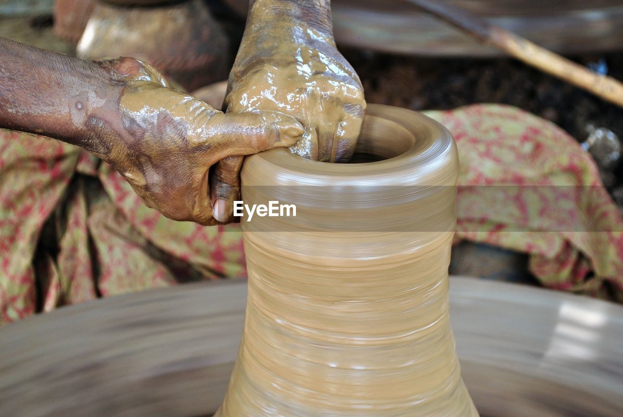 Cropped image of craftperson making pottery