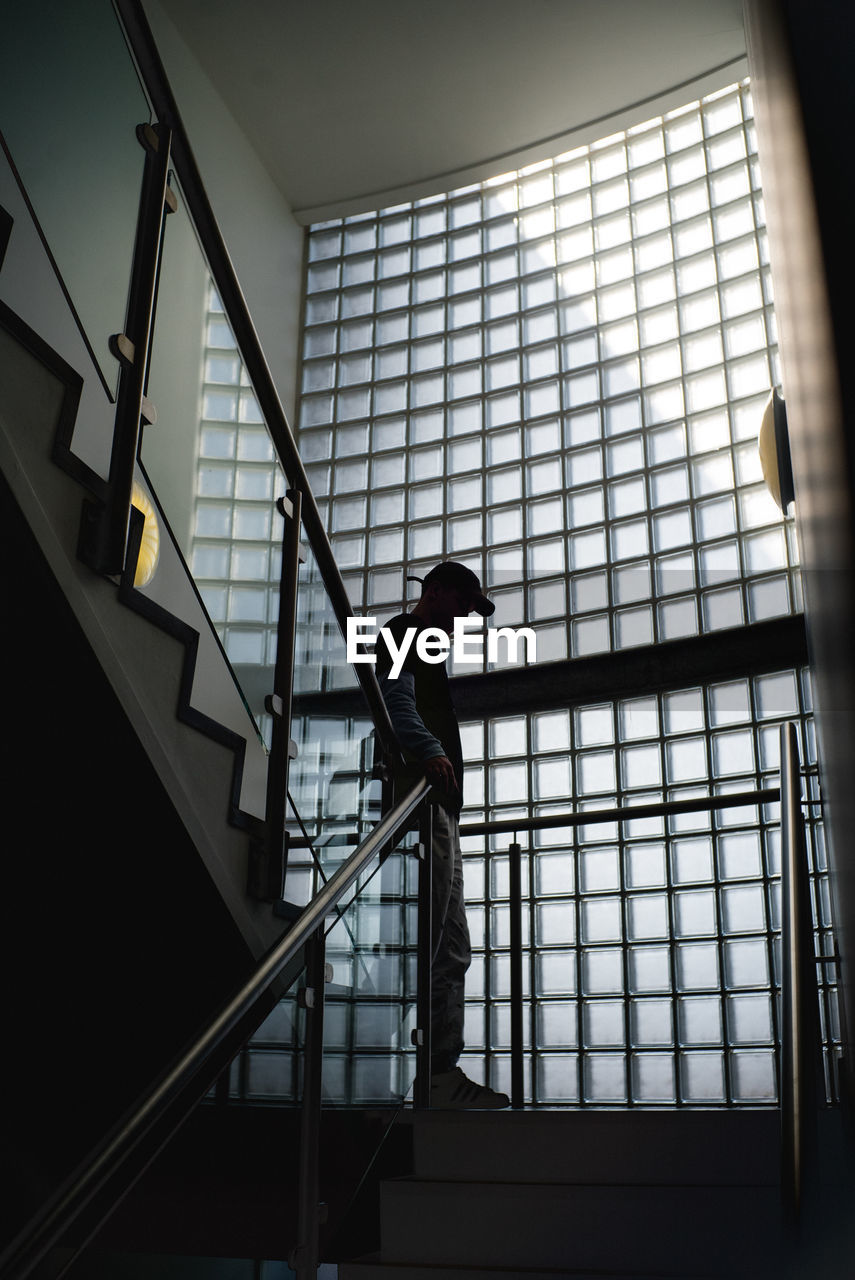 Man standing against railing in building