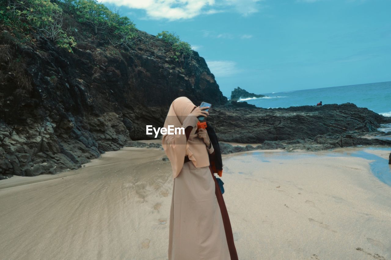 Woman on beach against sky