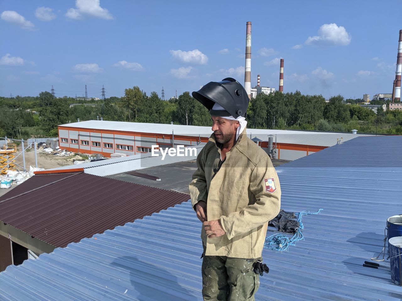 Full length of man standing by umbrella against sky