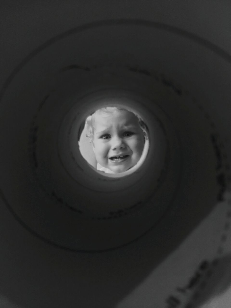 Scared boy seen through pipe